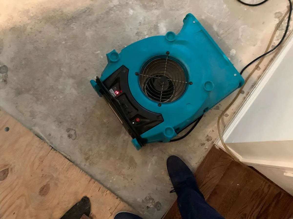 Air mover drying subfloor during Commercial Water Damage Restoration in Stowe
